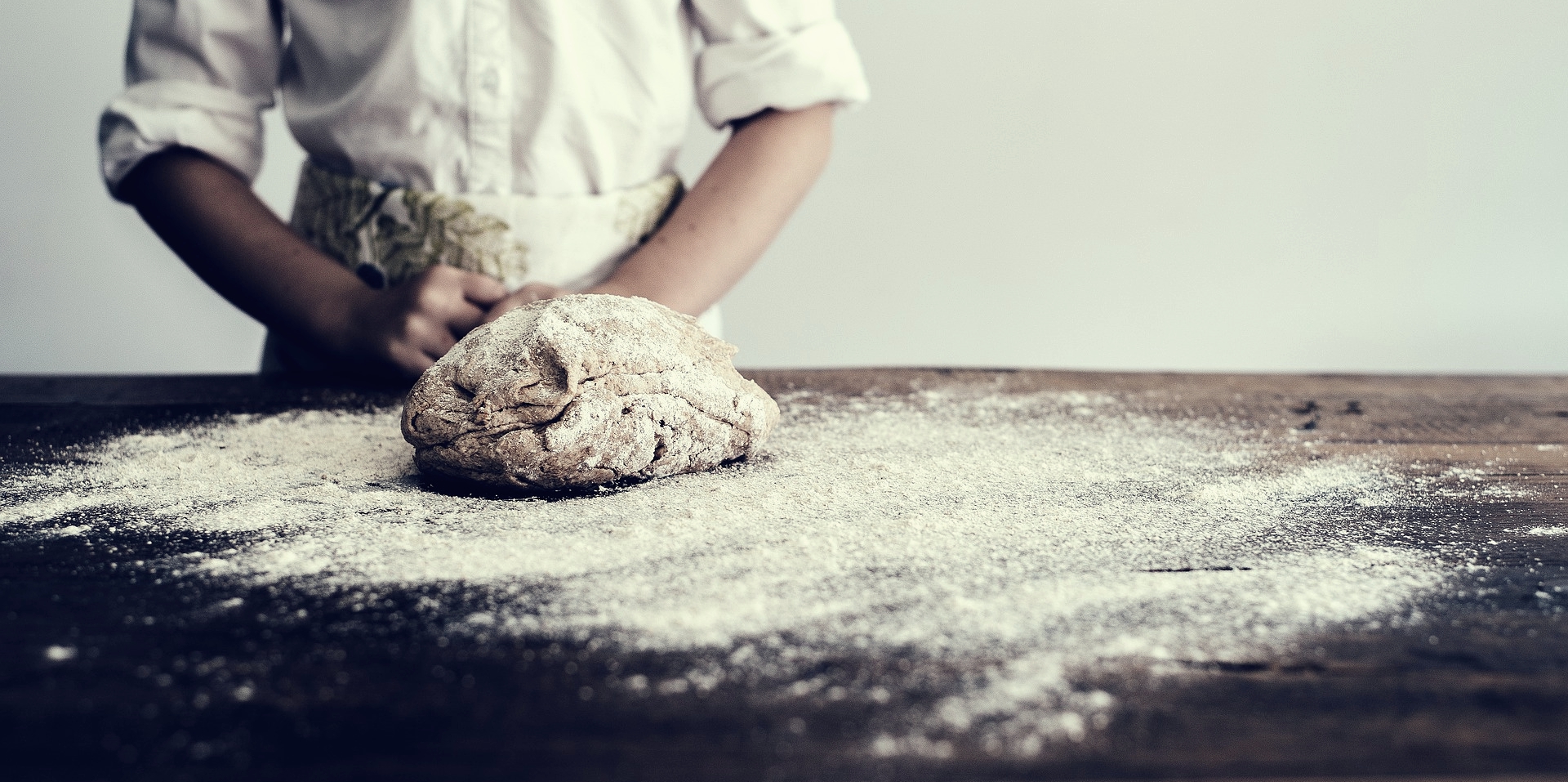 baker standing in font of dough